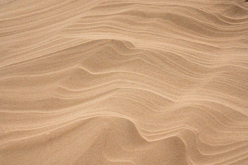 Abstrakte Linien im Sand als Symbol für Struktur, Ordnung und systematische Kategorienlogik im Hotelbetrieb